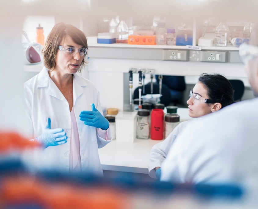 Immagine di due scienziati in laboratorio, con camici bianchi e occhiali protettivi