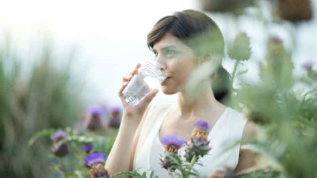 donna che beve acqua da un bicchiere