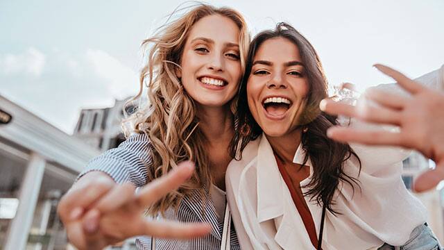 Due giovani donne che sorridono all'aperto