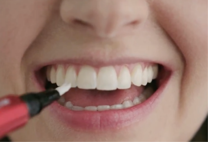 Presiona el lápiz blanqueador de dientes Optic White O2 de Colgate para liberar el suero para la rutina de blanqueamiento de dientes de Colgate. 